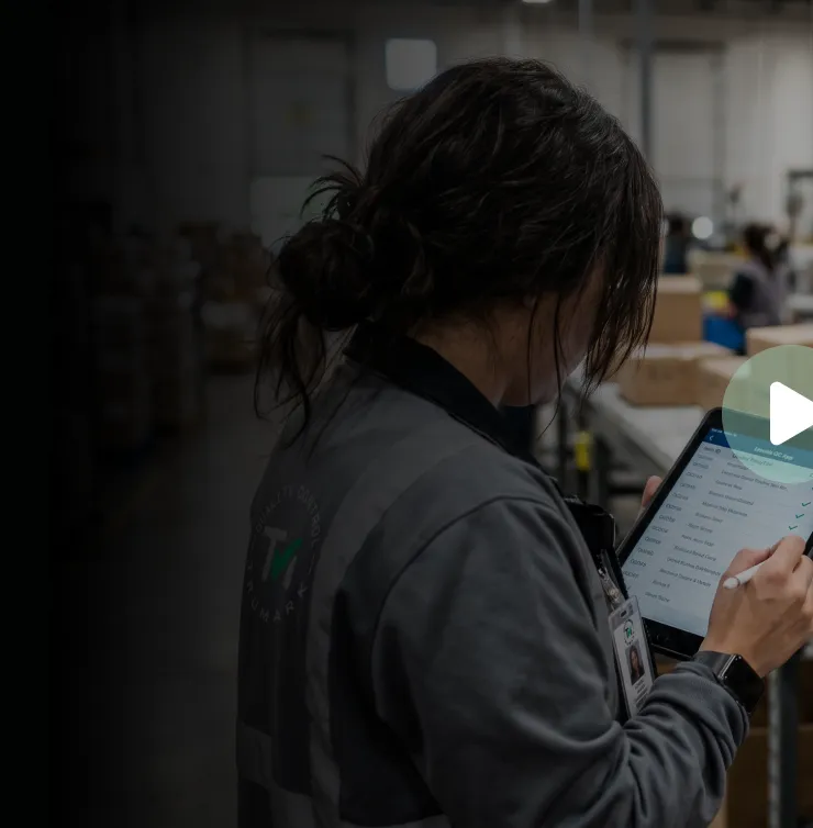 TruMark QC inspector reviewing a quality checklist on a tablet in a warehouse